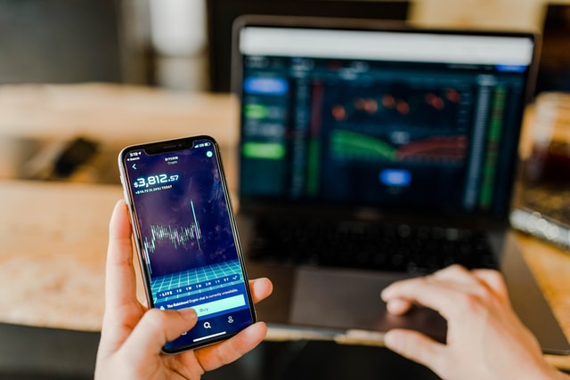 Laptop and phone with market graphs